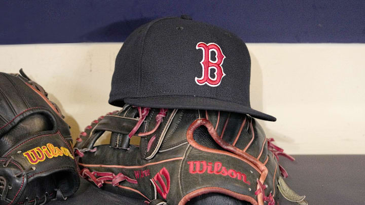 May 27, 2025; Milwaukee, Wisconsin, USA; A Boston Red Sox hat and glove sit in the dug out before a game against the Milwaukee Brewers at American Family Field. Mandatory Credit: Michael McLoone-Imagn Images