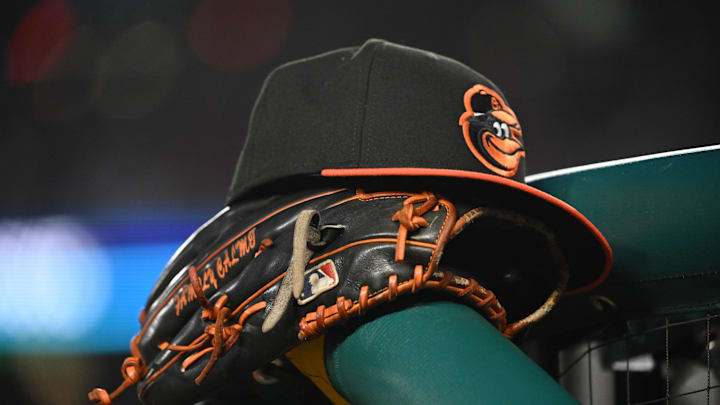 May 8, 2024; Washington, District of Columbia, USA; A Baltimore Orioles hat and glove rest on the dugout rail during a game against the Washington Nationals at Nationals Park. Mandatory Credit: Rafael Suanes-Imagn Images