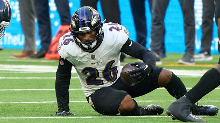 Oct 15, 2023; London, United Kingdom;  Baltimore Ravens safety Geno Stone (26) stumbles and carries the ball during the second half of an NFL International Series game at Tottenham Hotspur Stadium. Mandatory Credit: Peter van den Berg-Imagn Images