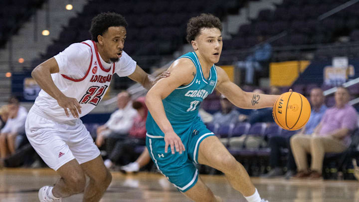Jacob Meyer (12) brings the ball up court during the Coastal Carolina University vs University of Louisiana at Lafayette basketball game in the second round of the Sun Belt Conference Men's Basketball Championship at the Pensacola Bay Center on Thursday, March 7, 2024.