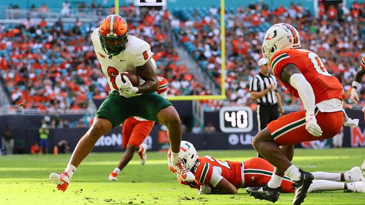 Sep 7, 2024; Miami Gardens, Florida, USA; Florida A&M Rattlers tight end Koby Gross (6) runs with the football past Miami Hurricanes defensive back Jadais Richard (25) during the first quarter at Hard Rock Stadium. Mandatory Credit: Sam Navarro-Imagn Images