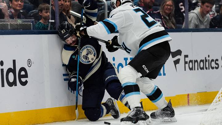 Oct 3, 2026; Columbus, Ohio, USA;  Utah Mammoth defenseman Andrew Peeke (20) battles against Columbus Blue Jackets right wing Conor Garland (83) for the puck in the third period at Nationwide Arena. Mandatory Credit: Aaron Doster-Imagn Images