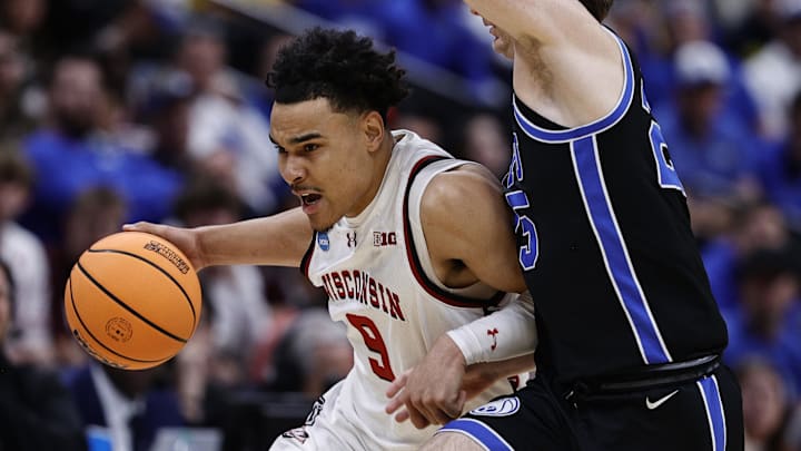 Mar 22, 2025; Denver, CO, USA; Wisconsin Badgers guard John Tonje (9) dribbles the ball past Brigham Young Cougars guard Dawson Baker (25) during the first half in the second round of the NCAA Tournament  at Ball Arena. 