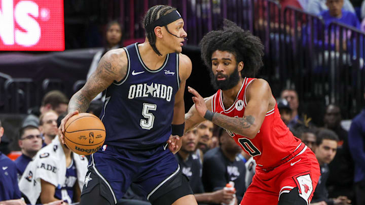 Apr 7, 2024; Orlando, Florida, USA; Orlando Magic forward Paolo Banchero (5) moves the ball around Chicago Bulls guard Coby White (0) during the second half at KIA Center. Mandatory Credit: Mike Watters-Imagn Images