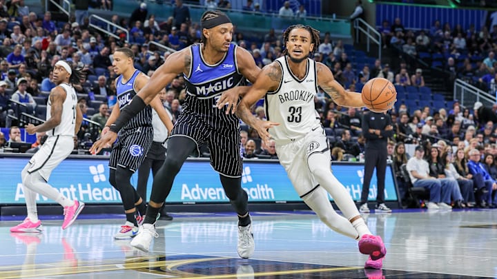 Nov 14, 2025; Orlando, Florida, USA; Brooklyn Nets center Nic Claxton (33) drives to the basket around Orlando Magic center Wendell Carter Jr. (34) during the first quarter at Kia Center. Mandatory Credit: Mike Watters-Imagn Images
