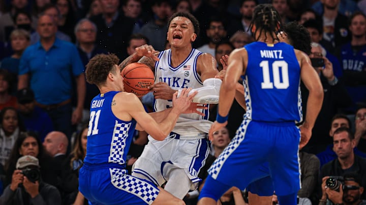 Nov 9, 2021; New York, New York, USA; Duke Blue Devils forward Paolo Banchero (5) reacts while being defended by Kentucky Wildcats guard Davion Mintz (10) and guard Kellan Grady (31) during the second half at Madison Square Garden. Mandatory Credit: Vincent Carchietta-Imagn Images