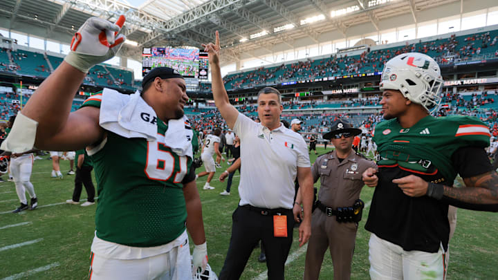 Nov 23, 2024; Miami Gardens, Florida, USA; Miami Hurricanes head coach Mario Cristobal celebrates with Miami Hurricanes offensive lineman Francis Mauigoa (61) and tight end Elijah Arroyo (8) after the game against the Wake Forest Demon Deacons at Hard Rock Stadium. Mandatory Credit: Sam Navarro-Imagn Images