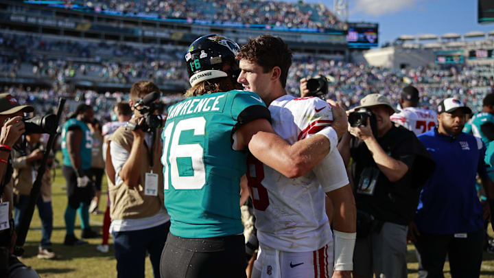 Jacksonville Jaguars quarterback Trevor Lawrence (16) hugs New York Giants quarterback Daniel Jones
