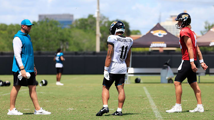 From left, Jacksonville Jaguars head coach Liam Coen, wide receiver Parker Washington (11) and quarterback Trevor Lawrence (16) talk after an NFL training camp session at the Miller Electric Center, Thursday, Aug. 14, 2025 in Jacksonville, Fla. From left, Jacksonville Jaguars head coach Liam Coen, wide receiver Parker Washington (11) and quarterback Trevor Lawrence (16) talk after an NFL training camp session at the Miller Electric Center, Thursday, Aug. 14, 2025 in Jacksonville, Fla.