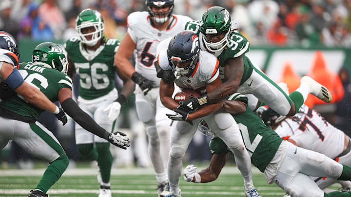 Sep 29, 2024; East Rutherford, New Jersey, USA; Denver Broncos running back Jaleel McLaughlin (38) fights for yards as New York Jets safety Tony Adams (22) and defensive end Takk McKinley (93) tackle during the second half at MetLife Stadium. 
