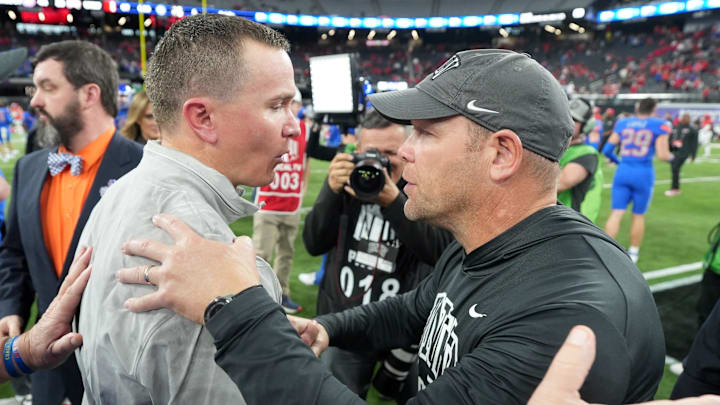 Boise State Broncos head coach Spencer Danielson (left) and UNLV Rebels head coach Barry Odom shake hands.