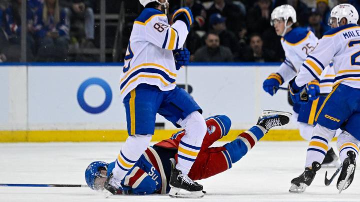 Apr 8, 2026; New York, New York, USA; New York Rangers left wing Alexis Lafrenière (13) lands on the ice after colliding with Buffalo Sabres right wing Alex Tuch (89) during the first period at Madison Square Garden. Mandatory Credit: Dennis Schneidler-Imagn Images