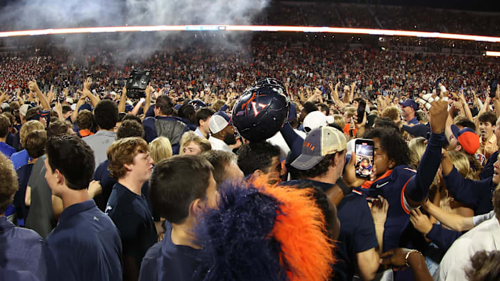 Sep 26, 2025; Charlottesville, Virginia, USA; Virginia Cavaliers players and fans celebrate on the field after the Cavaliers' win over the Florida State Seminoles in two overtimes at Scott Stadium. Mandatory Credit: Geoff Burke-Imagn Images