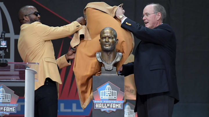 Aug 3, 2019; Canton, OH, USA; Champ Bailey (left) and presenter and agent Jack Reale unveil bust of Bailey during the Pro Football Hall of Fame Enshrinement at Tom Benson Hall of Fame Stadium. Mandatory Credit: Kirby Lee-Imagn Images