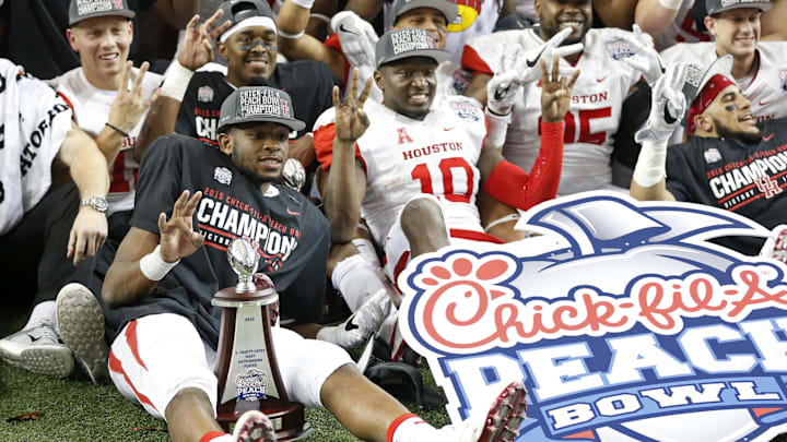 Dec 31, 2015; Atlanta, GA, USA; Houston Cougars quarterback Greg Ward Jr. (L) poses with teammates for a photo after defeating the Florida State Seminoles 38-24 during the 2015 Chick-fil-A Peach Bowl at the Georgia Dome. Mandatory Credit: Jason Getz-Imagn Images