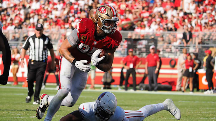 Oct 6, 2024; Santa Clara, California, USA; San Francisco 49ers tight end George Kittle (85) runs with the ball above Arizona Cardinals linebacker Kyzir White (7) during the fourth quarter at Levi's Stadium. Mandatory Credit: Kelley L Cox-Imagn Images