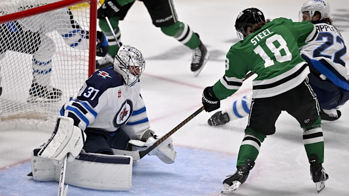 May 17, 2025; Dallas, Texas, USA; Winnipeg Jets goaltender Connor Hellebuyck (37) stops a shot by Dallas Stars center Sam Steel (18) during the first period in game six of the second round of the 2025 Stanley Cup Playoffs at American Airlines Center. Mandatory Credit: Jerome Miron-Imagn Images