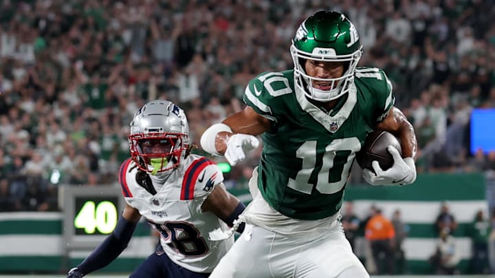 Sep 19, 2024; East Rutherford, New Jersey, USA; New York Jets wide receiver Allen Lazard (10) runs with the ball for a touchdown against New England Patriots cornerback Alex Austin (28) during the first quarter at MetLife Stadium. 