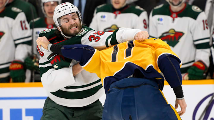 Jan 18, 2025; Nashville, Tennessee, USA;  Minnesota Wild right wing Ryan Hartman (38) and Nashville Predators center Mark Jankowski (17) exchange blows during the first period at Bridgestone Arena. Mandatory Credit: Steve Roberts-Imagn Images