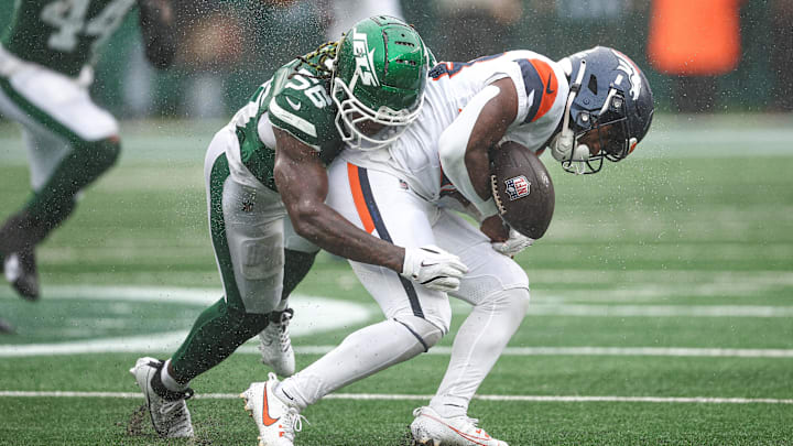 Sep 29, 2024; East Rutherford, New Jersey, USA; Denver Broncos running back Tyler Badie (28) fumbles after being hit by New York Jets linebacker Quincy Williams (56) during the first half at MetLife Stadium. Sep 29, 2024; East Rutherford, New Jersey, USA; Denver Broncos running back Tyler Badie (28) fumbles after being hit by New York Jets linebacker Quincy Williams (56) during the first half at MetLife Stadium.