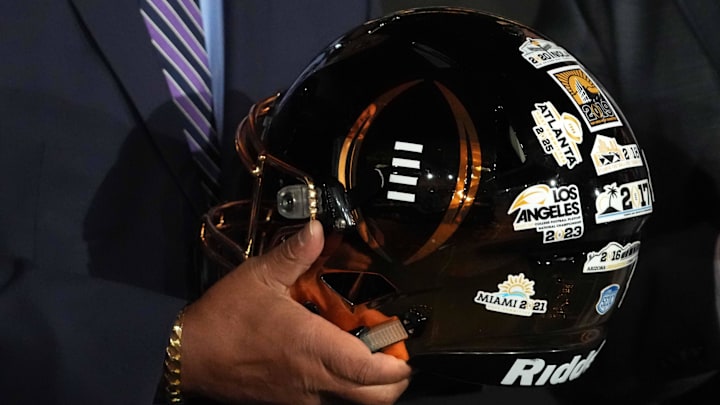 Jan 21, 2025; Atlanta, GA, USA; College Football Playoff executive director Rich Clark holds a helmet with stickers of past CFP national championship host cities during the CFP National Championship Host Committee handoff press conference at The Westin Peachtree Plaza, Savannah Ballroom. Mandatory Credit: Kirby Lee-Imagn Images