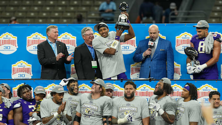 Huskies quarterback Michael Penix Jr. (9) holds up the offensive MVP trophy at the 2022 Alamo Bowl after beating Texas 27-20.