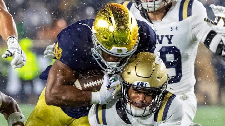 Nov 8, 2025; South Bend, Indiana, USA; Notre Dame Fighting Irish running back Jadarian Price (24) collides with Navy Midshipmen cornerback Phillip Hamilton (18) during the second half at Notre Dame Stadium. Mandatory Credit: Michael Caterina-Imagn Images