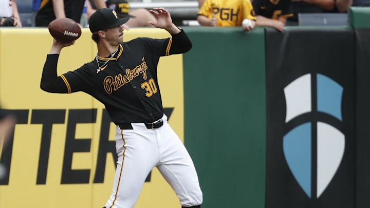 Jun 5, 2024; Pittsburgh, Pennsylvania, USA;  Pittsburgh Pirates starting pitcher Paul Skenes (30) tosses a football in the outfield to warm up before pitching against the Los Angeles Dodgers at PNC Park. Mandatory Credit: Charles LeClaire-Imagn Images