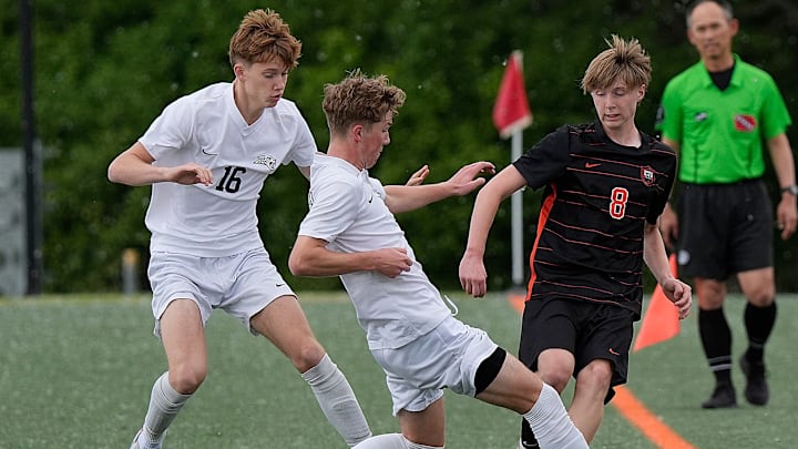 Ames’ mid-fielder Jamison Lynch (8) passes the ball between Ankeny Centennial defender/midfielder Maddox Rash (18) and defender/forward Andrew Kruger (16) during the first half in the 4A high school boys sub-state final at Ames High Soccer field on May 29, 2025, in Ames, Iowa.