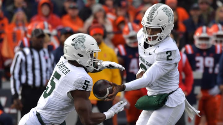 Nov 16, 2024; Champaign, Illinois, USA; Michigan State Spartans quarterback Aidan Chiles (2) hands the ball to running back Nate Carter (5) during the first half against the Illinois Fighting Illini at Memorial Stadium. Mandatory Credit: Ron Johnson-Imagn Images