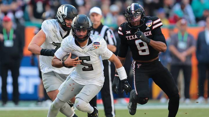 Jan 1, 2026; Miami Gardens, FL, USA; Oregon Ducks quarterback Dante Moore (5) carries the ball against the Texas Tech Red Raiders during the second half of the 2025 Orange Bowl and quarterfinal game of the College Football Playoff at Hard Rock Stadium. Mandatory Credit: Sam Navarro-Imagn Images