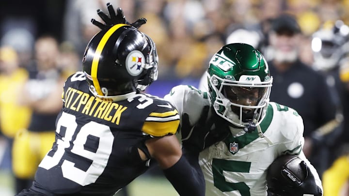 Oct 20, 2024; Pittsburgh, Pennsylvania, USA;  New York Jets wide receiver Garrett Wilson (5) runs after a catch as Pittsburgh Steelers safety Minkah Fitzpatrick (39) defends during the first quarter  at Acrisure Stadium. Mandatory Credit: Charles LeClaire-Imagn Images