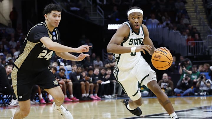 Mar 21, 2025; Cleveland, OH, USA; Michigan State Spartans guard Tre Holloman (5) dribbles defended by Bryant University Bulldogs guard Rafael Pinzon (24) in the second half during the NCAA Tournament First Round at Rocket Mortgage Fieldhouse. Mandatory Credit: Rick Osentoski-Imagn Images