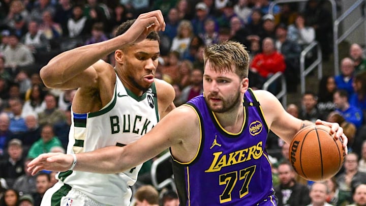 Mar 13, 2025; Milwaukee, Wisconsin, USA;  Los Angeles Lakers guard Luka Doncic (77) drives to the basket against Milwaukee Bucks forward Giannis Antetokounmpo (34) in the third quarter at Fiserv Forum. Mandatory Credit: Benny Sieu-Imagn Images