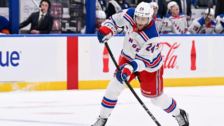 Apr 10, 2025; Elmont, New York, USA;  New York Rangers defenseman Carson Soucy (24) attempts a shot against the New York Islanders during the first period at UBS Arena. Mandatory Credit: Dennis Schneidler-Imagn Images