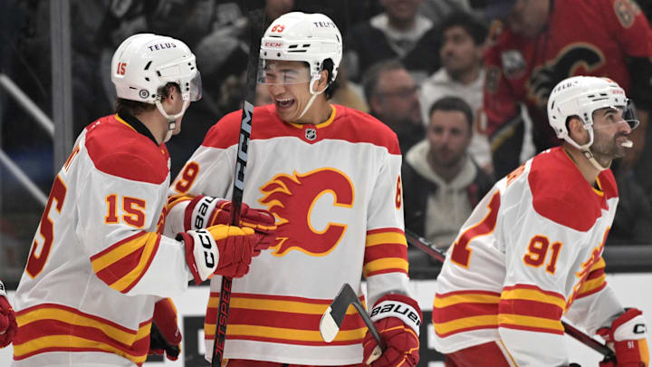 Apr 17, 2025; Los Angeles, California, USA;   Calgary Flames left wing Dryden Hunt (15), defenseman Zayne Parekh (89) and center Nazem Kadri (91) celebrate after a goal in the third period against the Los Angeles Kings at Crypto.com Arena. Mandatory Credit: Jayne Kamin-Oncea-Imagn Images
