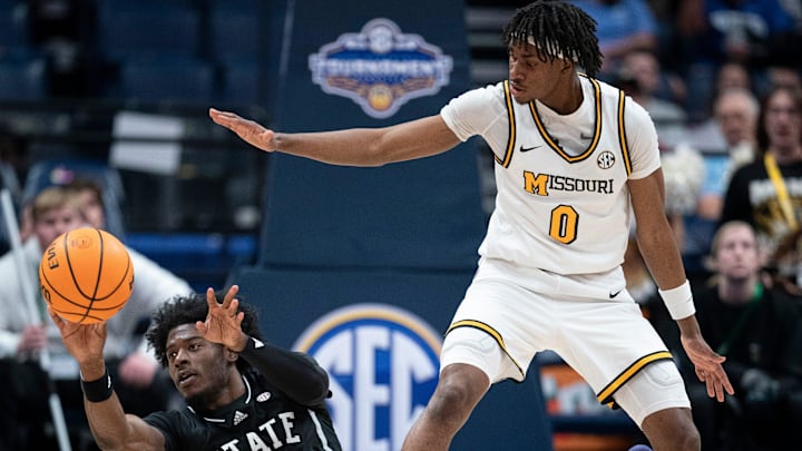 Mississippi State Bulldogs forward Cameron Matthews (4) passes while pressured by Missouri Tigers guard Anthony Robinson II (0) during their second round game of the SEC Men's Basketball Tournament at Bridgestone Arena in Nashville, Tenn., Thursday, March 13, 2025.