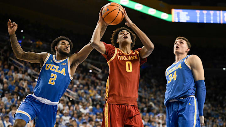 Feb 24, 2026; Los Angeles, California, USA; Southern California Trojans guard Alijah Arenas (0) drives to the basket past UCLA Bruins guard Donovan Dent (2) and forward Tyler Bilodeau (34) during the first half at Pauley Pavilion presented by Wescom Financial. Mandatory Credit: Robert Hanashiro-Imagn Images