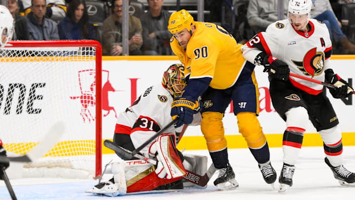 Feb 3, 2025; Nashville, Tennessee, USA; Ottawa Senators goaltender Anton Forsberg (31) blocks the puck as Nashville Predators center Ryan O'Reilly (90) gets in his way during the second period at Bridgestone Arena. Mandatory Credit: Steve Roberts-Imagn Images