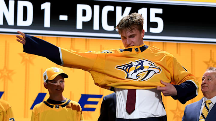 Jun 28, 2023; Nashville, Tennessee, USA; Nashville Predators draft pick Matthew Wood puts on his sweater after being selected with the fifteenth pick in round one of the 2023 NHL Draft at Bridgestone Arena. Mandatory Credit: Christopher Hanewinckel-Imagn Images