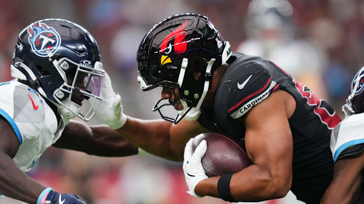 Arizona Cardinals tight end Elijah Higgins (84) attempts to stiff arm against the Tennessee Titans cornerback Roger McCreary (21) at State Farm Stadium in Glendale on Oct. 5, 2025.