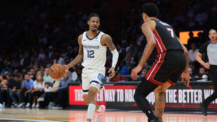 Apr 3, 2025; Miami, Florida, USA; Memphis Grizzlies guard Ja Morant (12) dribbles the basketball as Miami Heat center Kel'el Ware (7) defends during the first quarter at Kaseya Center. Mandatory Credit: Sam Navarro-Imagn Images