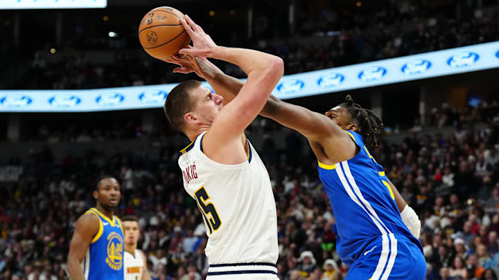 Dec 25, 2023; Denver, Colorado, USA; Golden State Warriors forward Kevon Looney (5) fouls Denver Nuggets center Nikola Jokic (15) in the second half at Ball Arena. Mandatory Credit: Ron Chenoy-Imagn Images