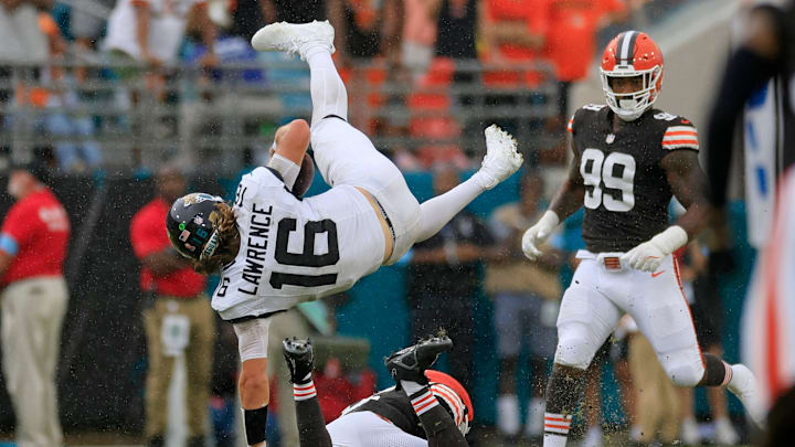 Jacksonville Jaguars quarterback Trevor Lawrence (16) is upended by Cleveland Browns linebacker Jeremiah Owusu-Koramoah (6) as defensive end Za'Darius Smith (99) looks on during the fourth quarter of an NFL football matchup Sunday, Sept. 15, 2024 at EverBank Stadium in Jacksonville, Fla. 