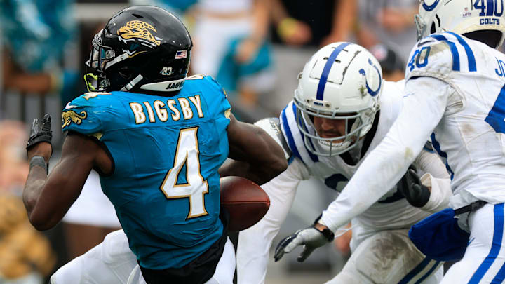 Jacksonville Jaguars running back Tank Bigsby (4) rushes for yards en route to a touchdown with the ball punched out by Indianapolis Colts defensive end Laiatu Latu (97), right, during the third quarter of an NFL football matchup Sunday, Oct. 6, 2024 at EverBank Stadium in Jacksonville, Fla.