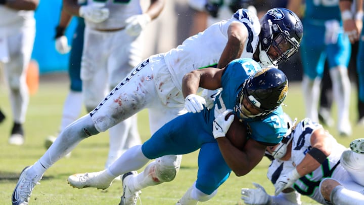 Jacksonville Jaguars running back Bhayshul Tuten (33) is tackled by Seattle Seahawks linebacker Ernest Jones (13) during the third quarter of an NFL football matchup, Sunday, Oct. 12, 2025, at EverBank Stadium in Jacksonville, Fla. The Seahawks defeated the Jaguars 20-12.