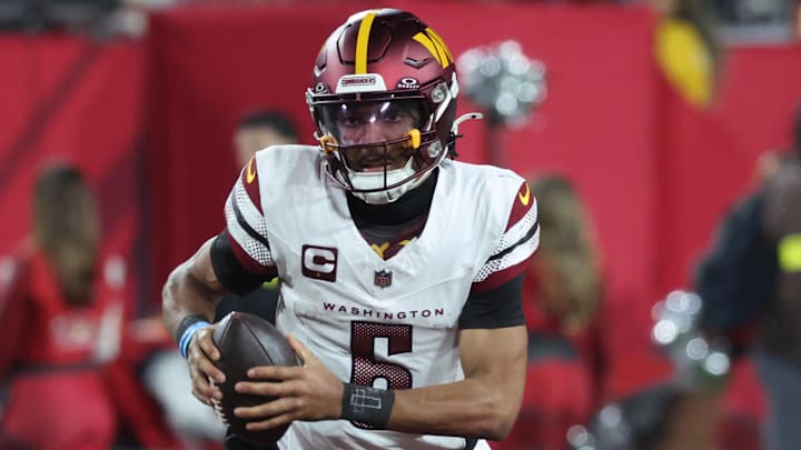 Jan 12, 2025; Tampa, Florida, USA; Washington Commanders quarterback Jayden Daniels (5) scrambles against the Tampa Bay Buccaneers during the second quarter of a NFC wild card playoff at Raymond James Stadium. Mandatory Credit: Kim Klement Neitzel-Imagn Images