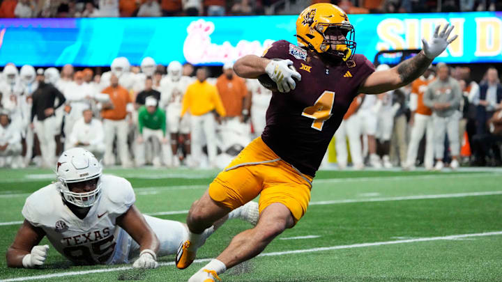 Arizona State running back Cam Skattebo (4) escapes a tackle by Texas defensive lineman Alfred Collins (95) during the fourth quarter in the Chick-fil-A Peach Bowl in Atlanta on Wednesday, Jan. 1, 2025. Arizona State running back Cam Skattebo (4) escapes a tackle by Texas defensive lineman Alfred Collins (95) during the fourth quarter in the Chick-fil-A Peach Bowl in Atlanta on Wednesday, Jan. 1, 2025.