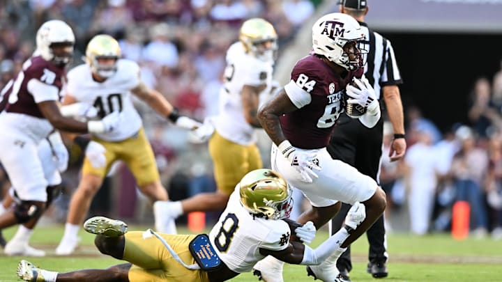 Texas A&M Aggies wide receiver Blake Buntyn runs the ball as Notre Dame Fighting Irish safety Adon Shuler.