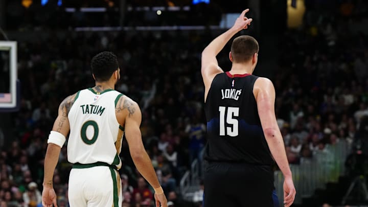 ; Boston Celtics forward Jayson Tatum (0) and Denver Nuggets center Nikola Jokic (15) during the first half at Ball Arena. Mandatory Credit: Ron Chenoy-Imagn Images